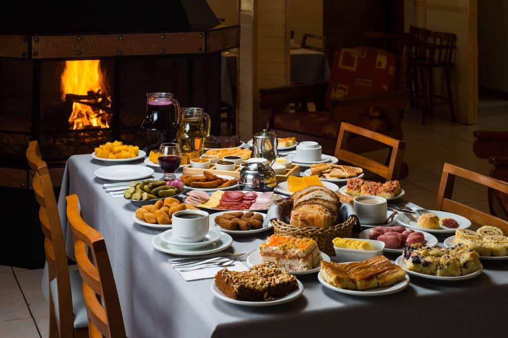 Mesa de café colonial na Serra Gaúcha, com pães, frios, bolos e salgados